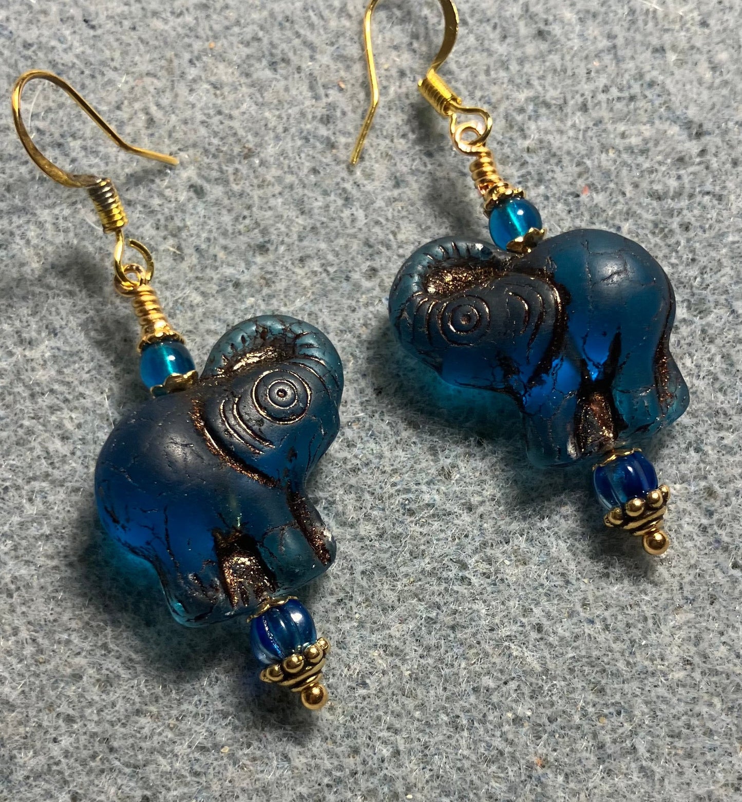 Dark turquoise (with copper inlay) Czech glass elephant bead earrings adorned with turquoise Czech glass beads.