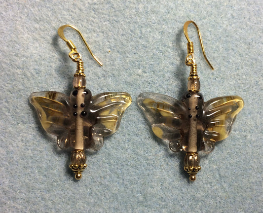 Brown, amber, and clear lamp work butterfly bead earrings adorned with light brown Czech glass beads.