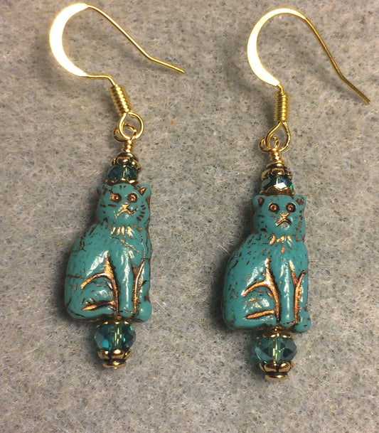 Small dark turquoise (with gold inlay) Czech glass cat bead earrings adorned with dark turquoise Chinese crystal beads.