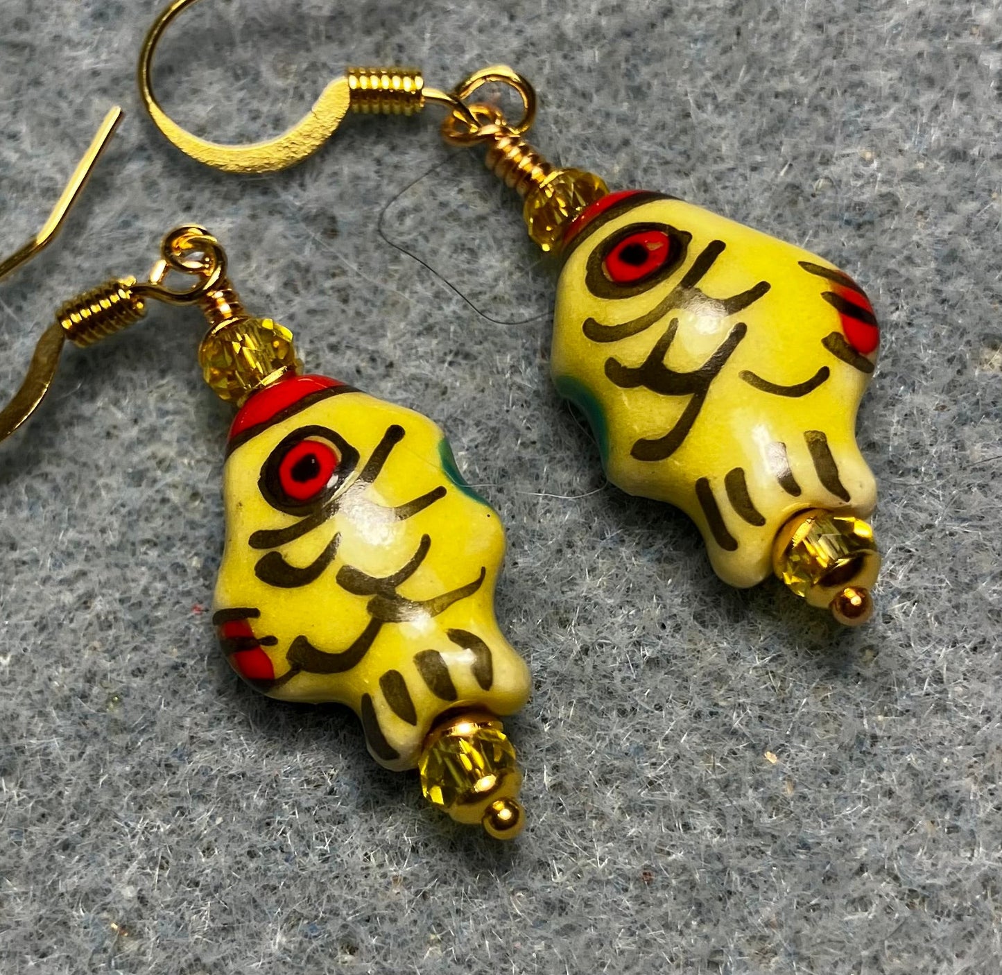 Small yellow, black, and red ceramic fish bead earrings adorned with yellow Chinese crystal beads.