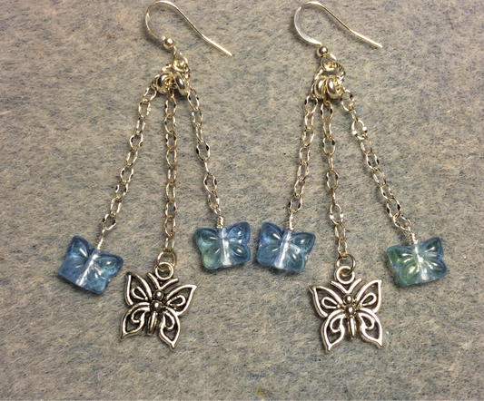 Small silver butterfly charm earrings attached to silver chain and adorned with small light blue Czech glass butterfly beads