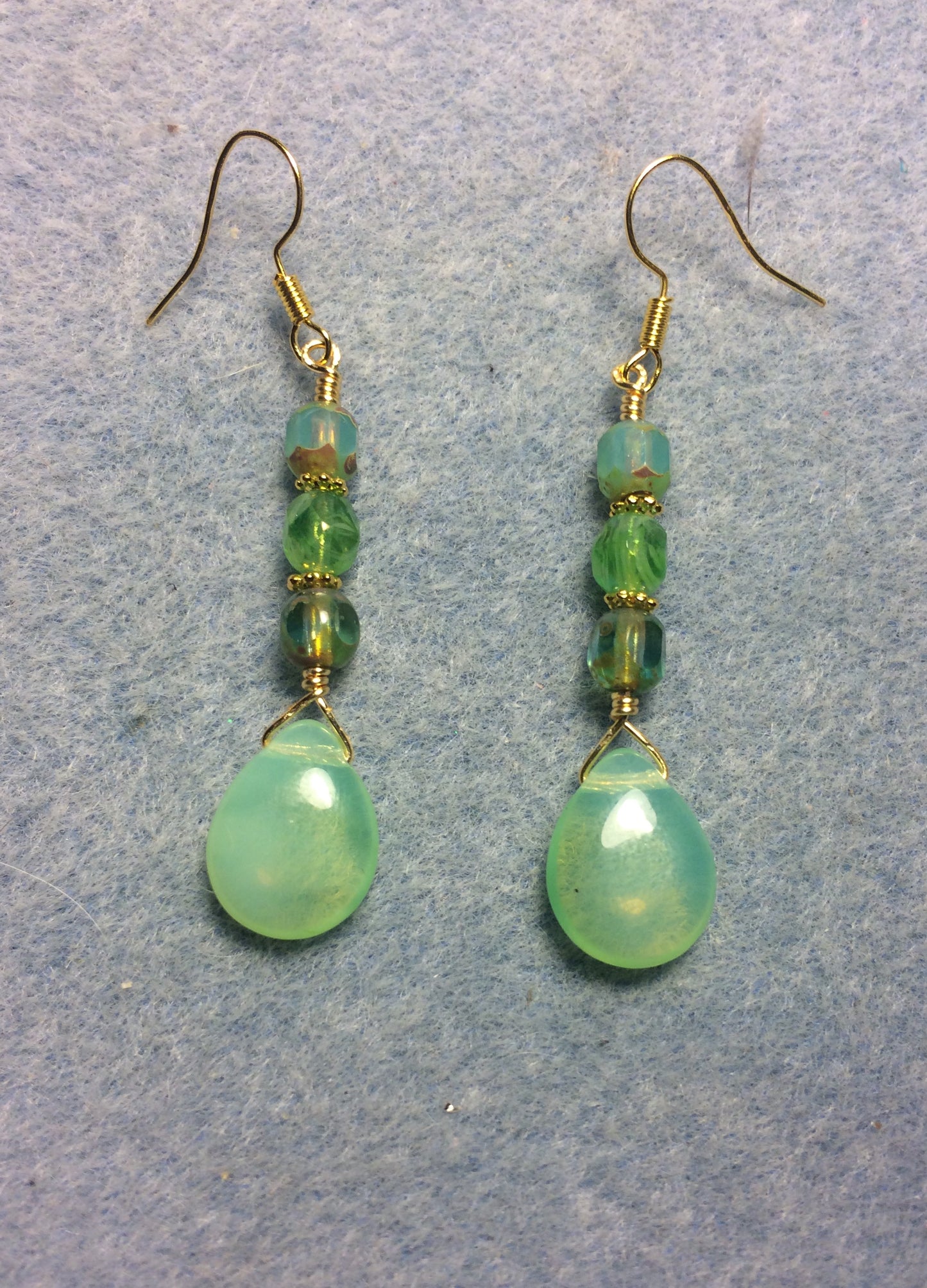 Opal green Czech glass pear drop bead earrings adorned with opal green Czech glass beads.