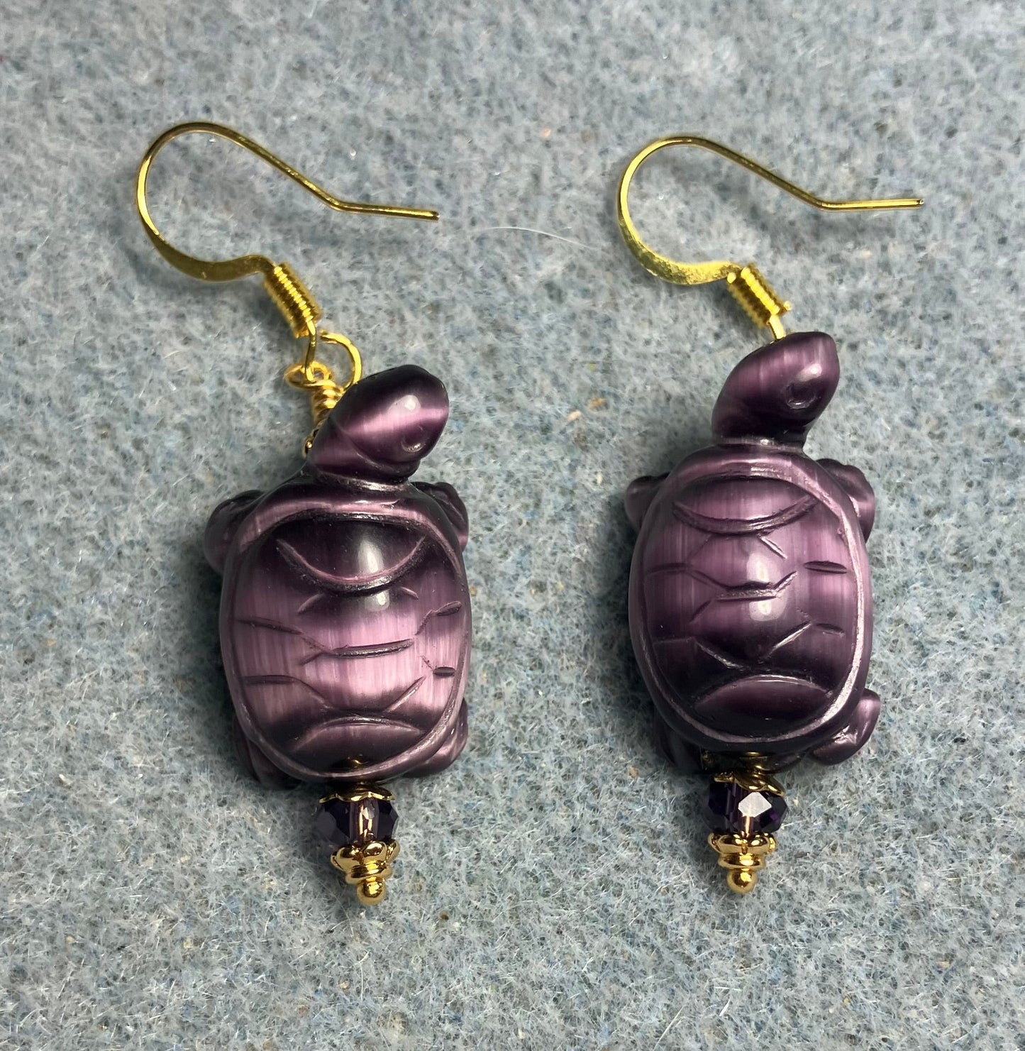 Purple fiber optic (cat’s eye) turtle bead earrings adorned with purple Chinese crystal beads.