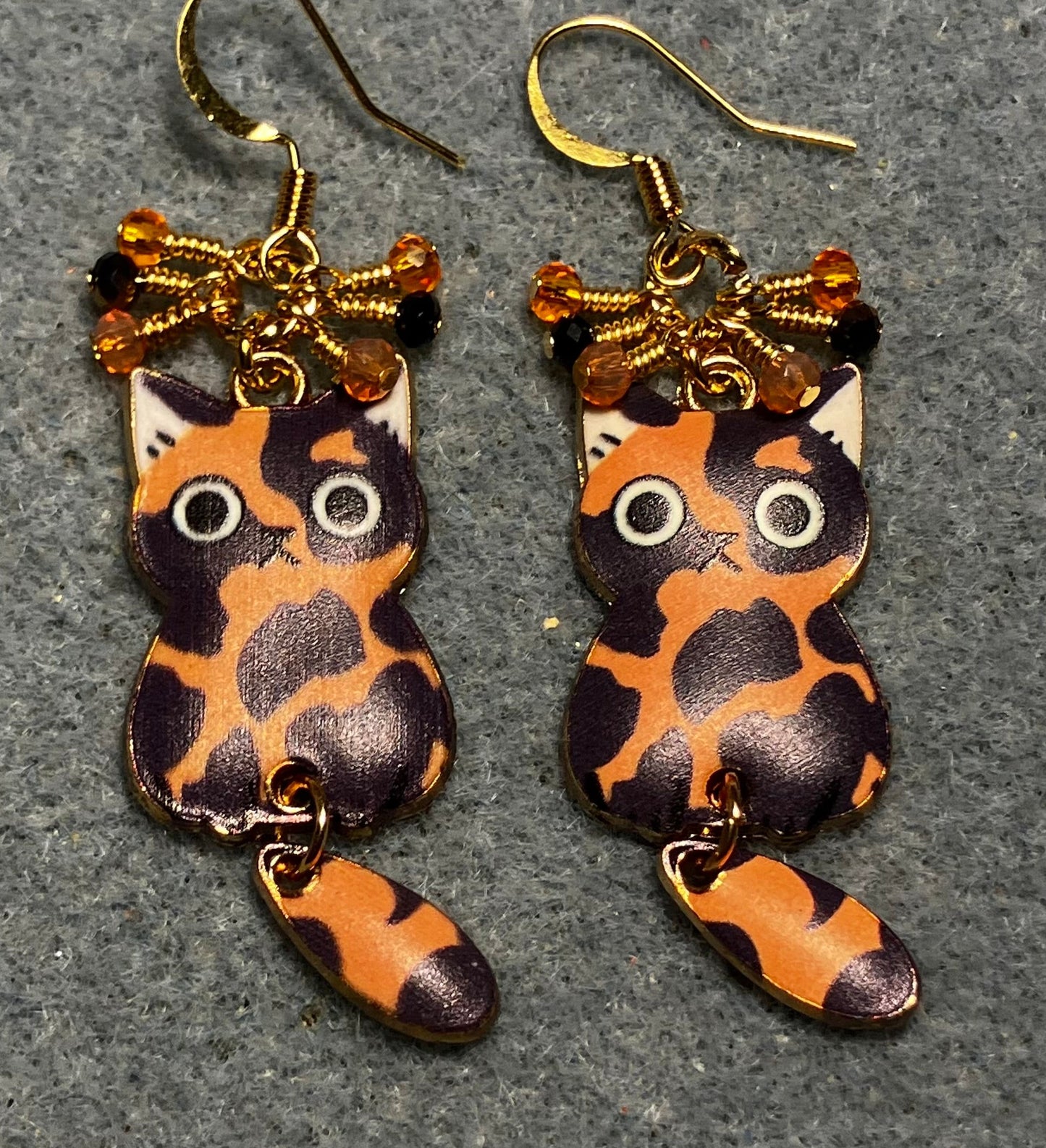 Orange, black, and white enamel calico cat charm earrings adorned with tiny dangling orange and black Chinese crystal beads.