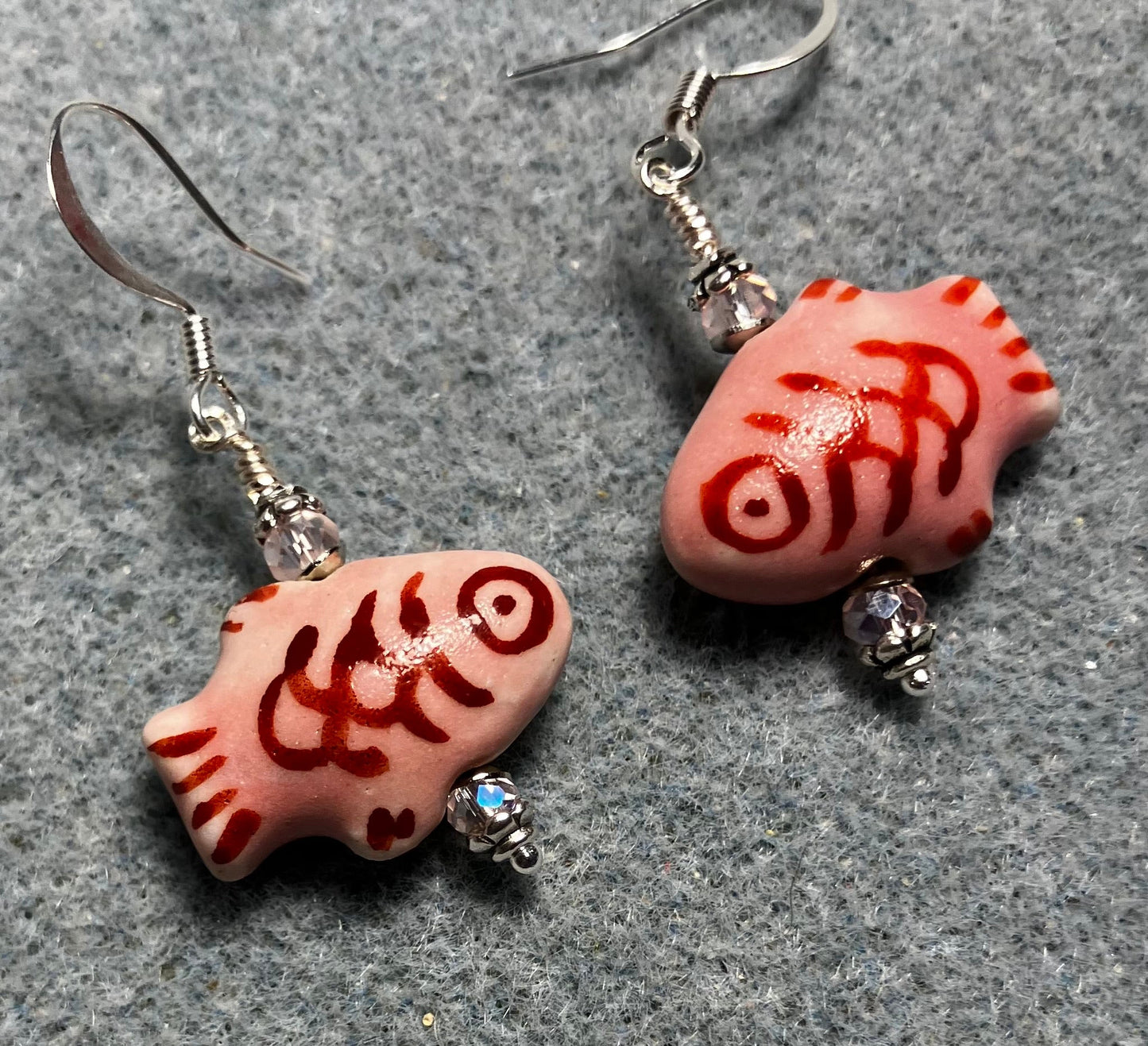 Pink and dark red ceramic fish bead earrings adorned with pink Chinese crystal beads.