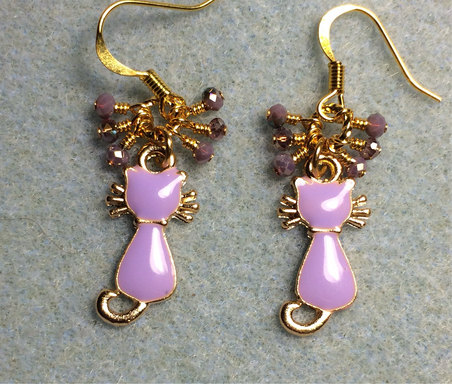 Small violet and gold enamel cat charm earrings adorned with tiny dangling violet Chinese crystal beads.