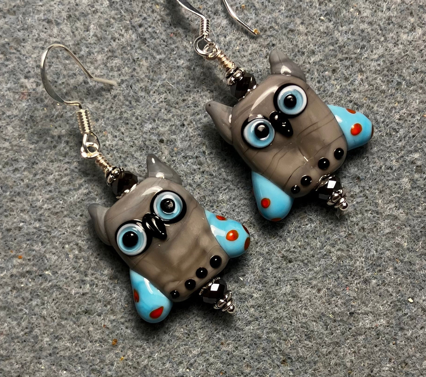 Gray and blue lamp work owl bead earrings adorned with gray Chinese crystal beads.