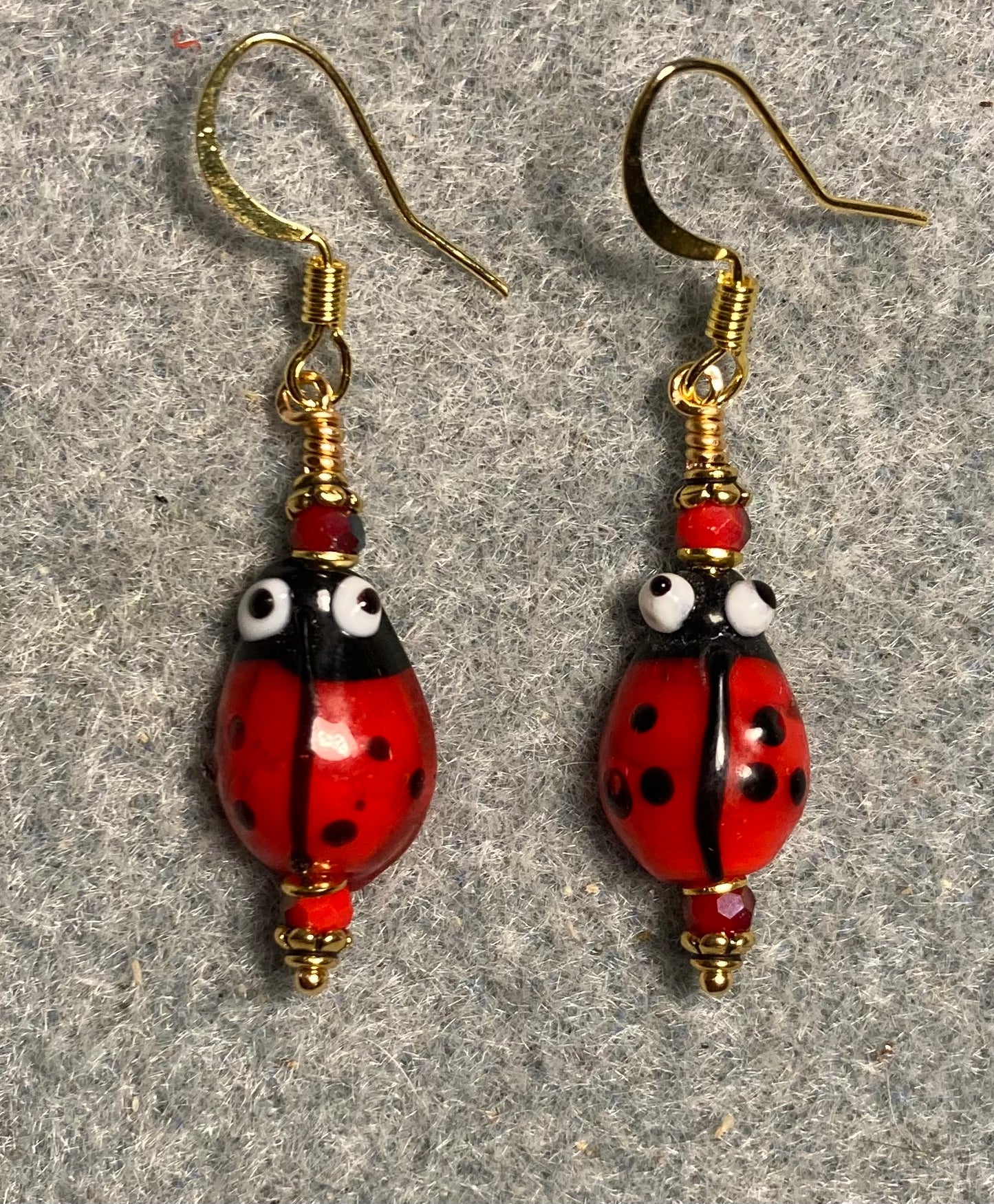 Small red and black lamp work ladybug bead earrings adorned with red Chinese crystal beads.