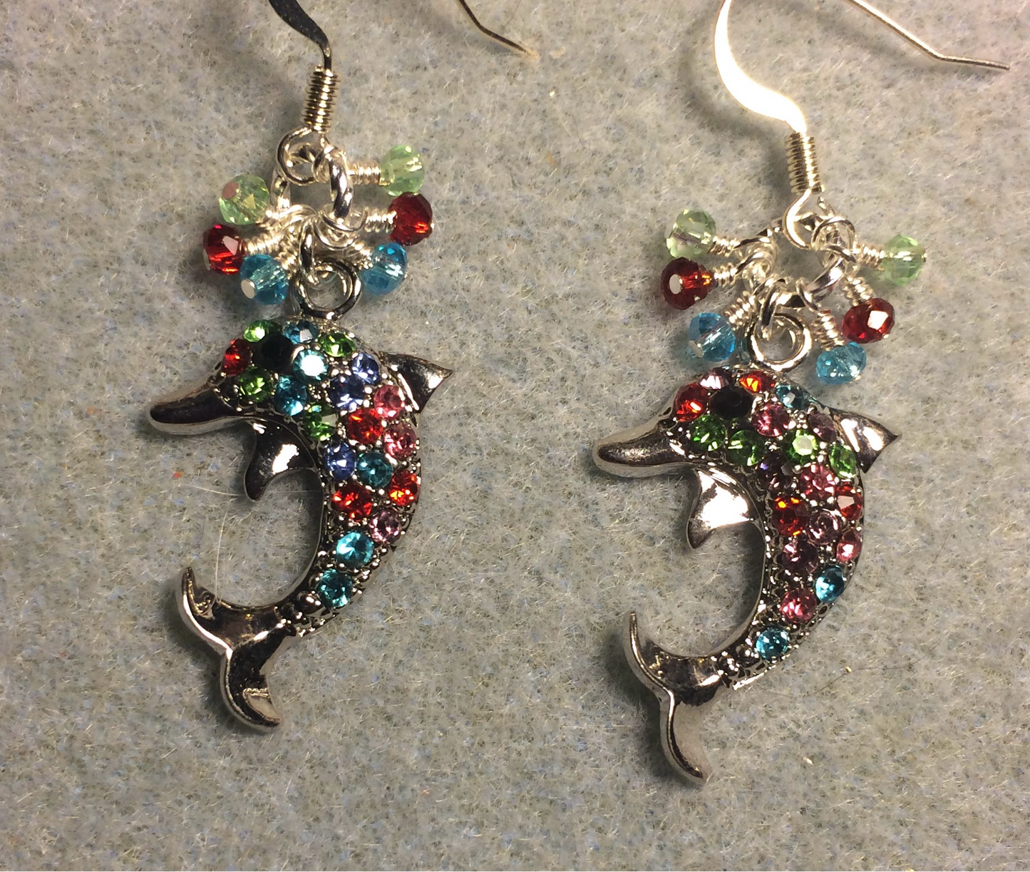 Silver and colored rhinestone dolphin charm earrings adorned with tiny dangling turquoise, red, and green Chinese crystal beads.