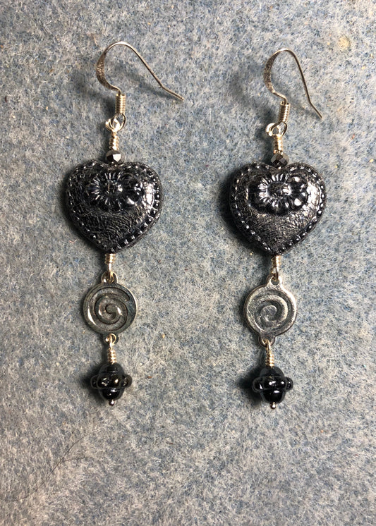 Silver black Czech glass heart bead earrings adorned with silver swirly links and silver black Czech glass Saturn beads.