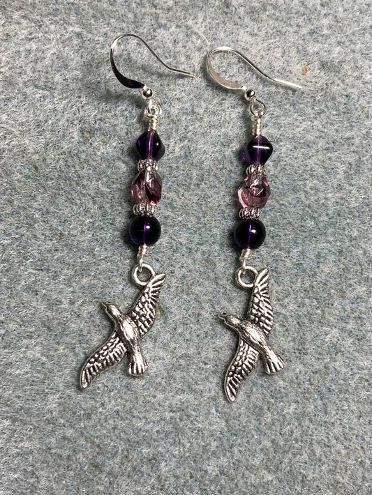 Silver flying bird charm earrings adorned with purple and violet Czech glass beads