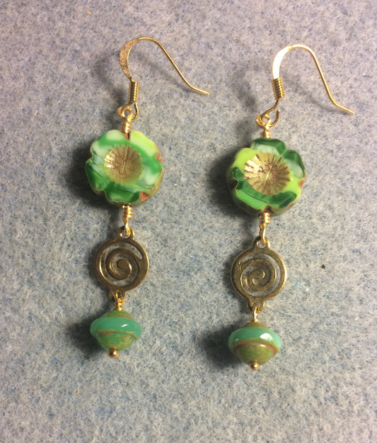 Dark and light green Czech glass pansy bead earrings adorned with gold swirly connectors and green Czech glass Saturn beads.