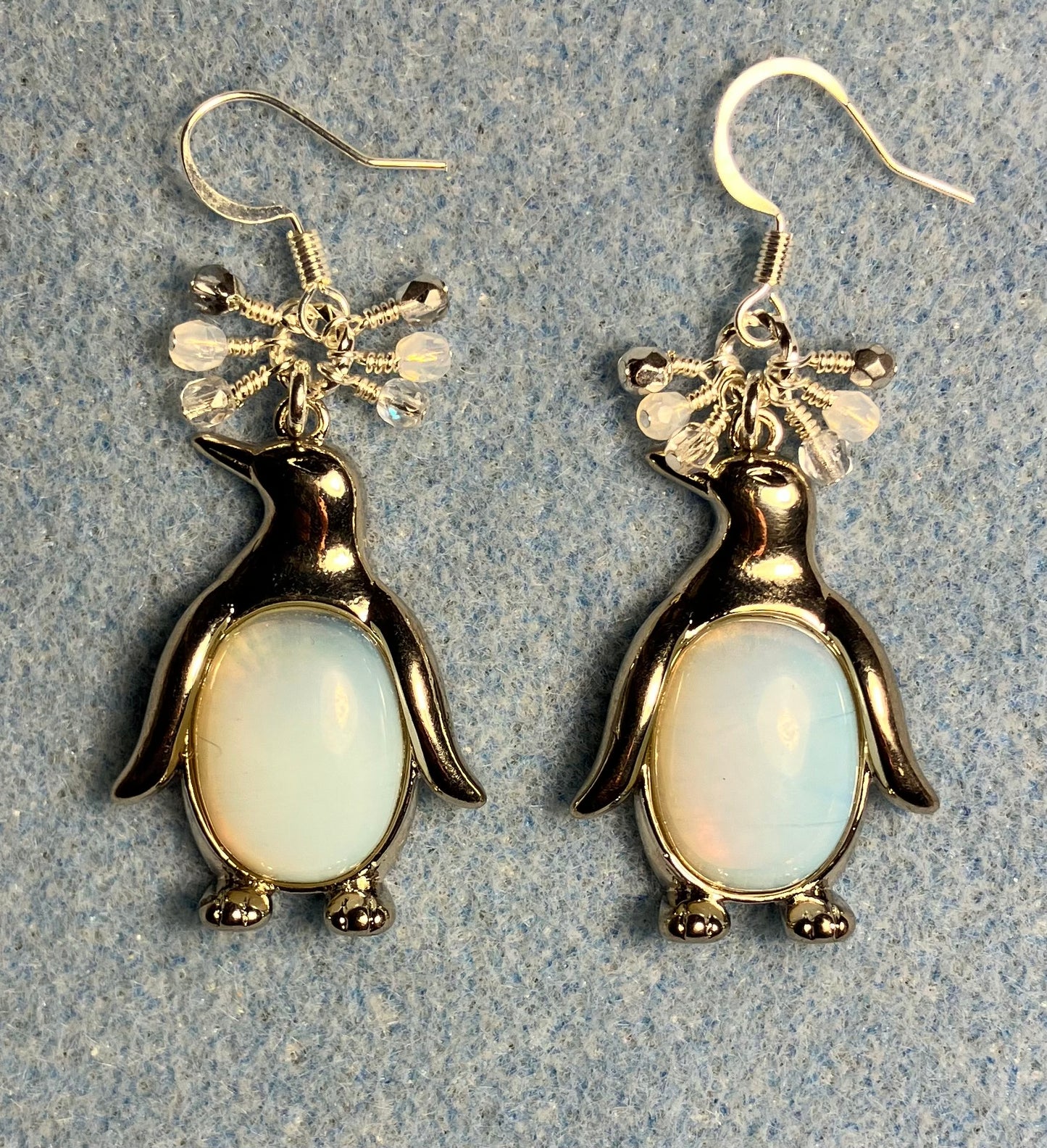 Large silver and opalite gemstone penguin charm earrings adorned with small dangling white, clear, and silver Czech glass beads.