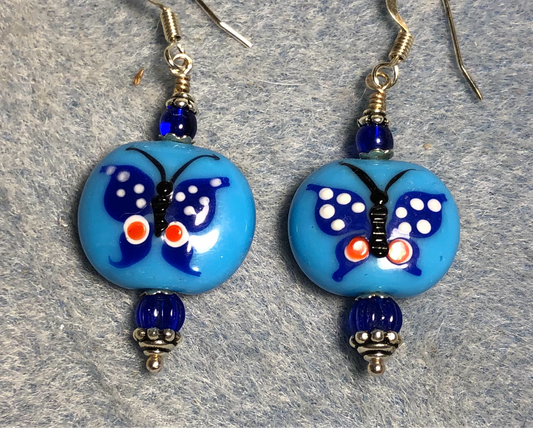 Light blue and dark blue lamp work butterfly bead earrings adorned with dark blue Czech glass beads.