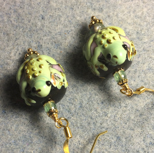 Green and black lamp work frog bead earrings adorned with green Czech glass beads.