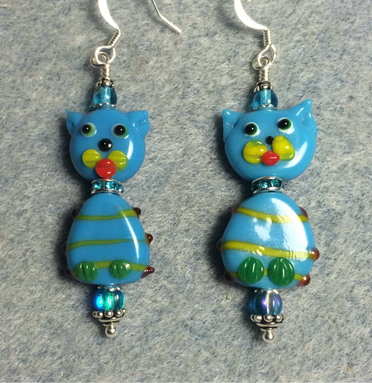 Turquoise and green lamp work cat bead earrings adorned with turquoise rhinestone rondelle “collars” and turquoise Czech glass beads.