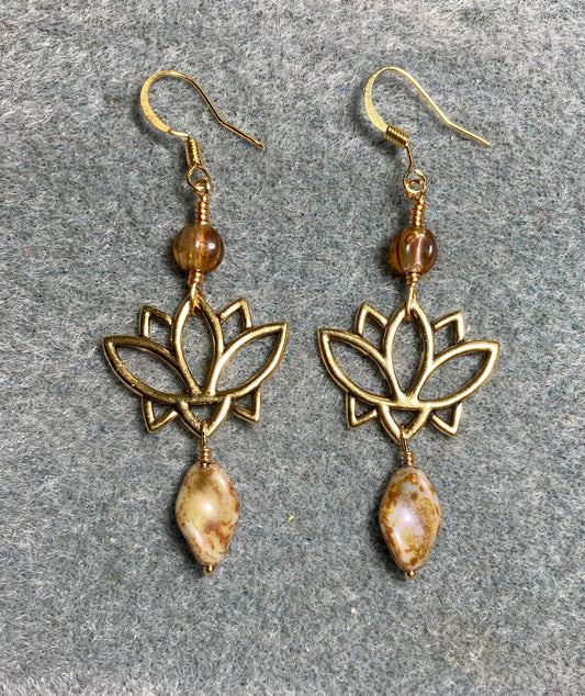 Gold lotus flower connector charm earrings adorned with beige Czech glass twist beads and beige Czech glass melon beads.