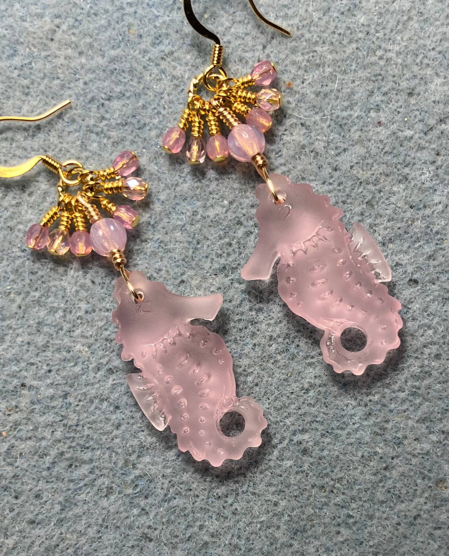 Pink sea glass seahorse pendant bead earrings adorned with pink Czech glass beads and tiny dangling pink Czech glass beads.