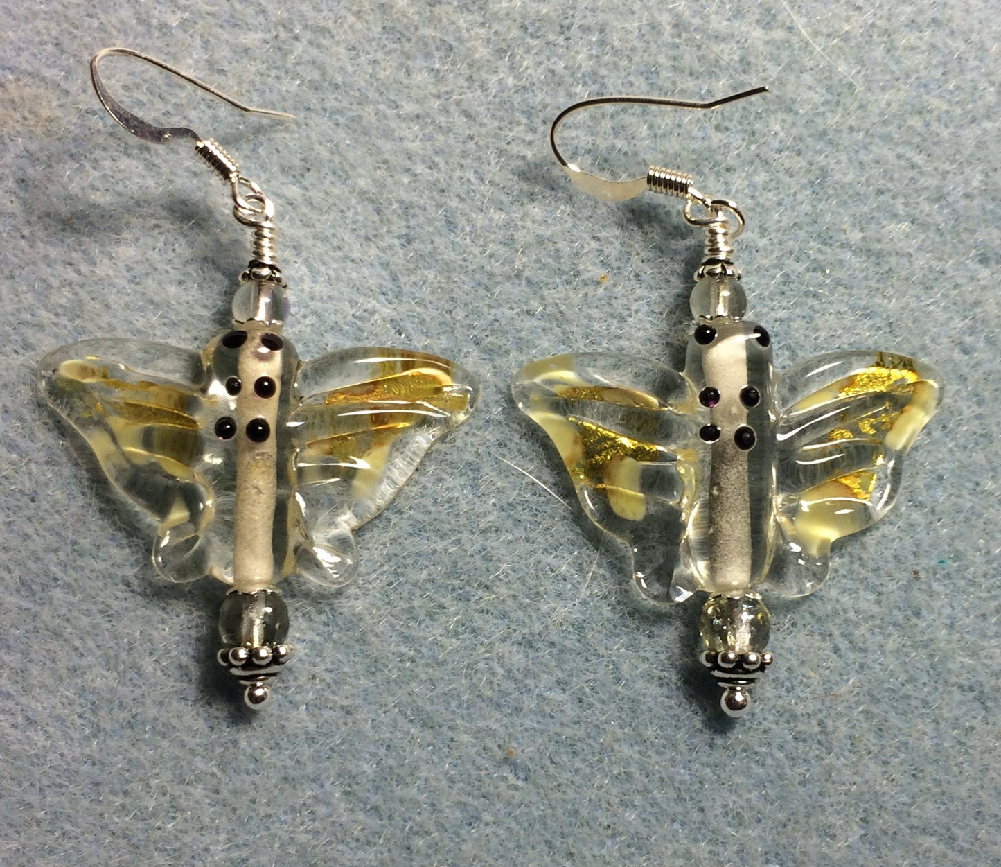 Amber and clear lamp work butterfly bead earrings adorned with clear Czech glass beads.