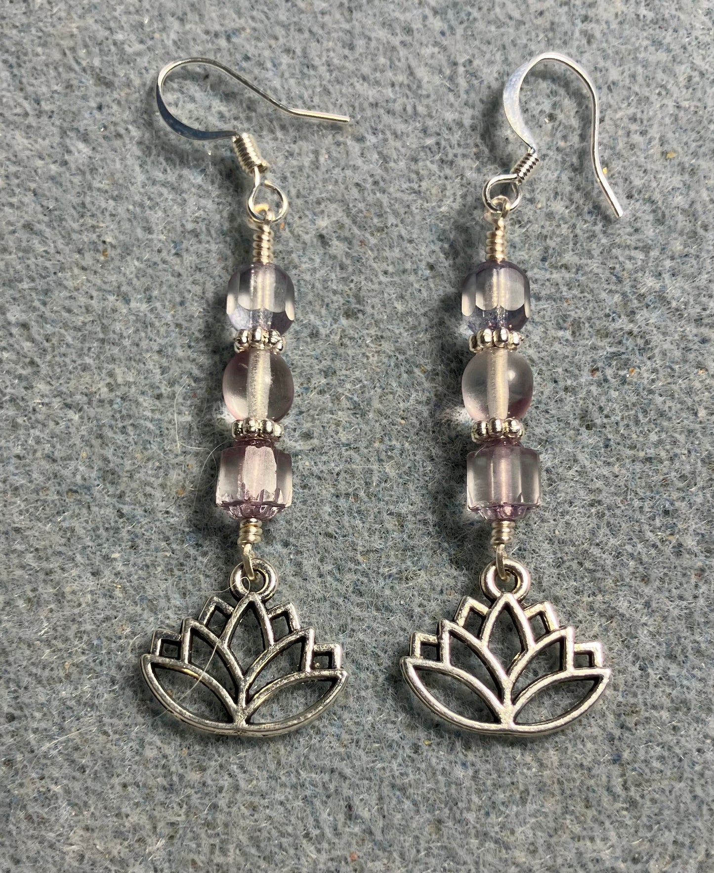 Silver lotus flower charm earrings adorned with light violet Czech glass beads.