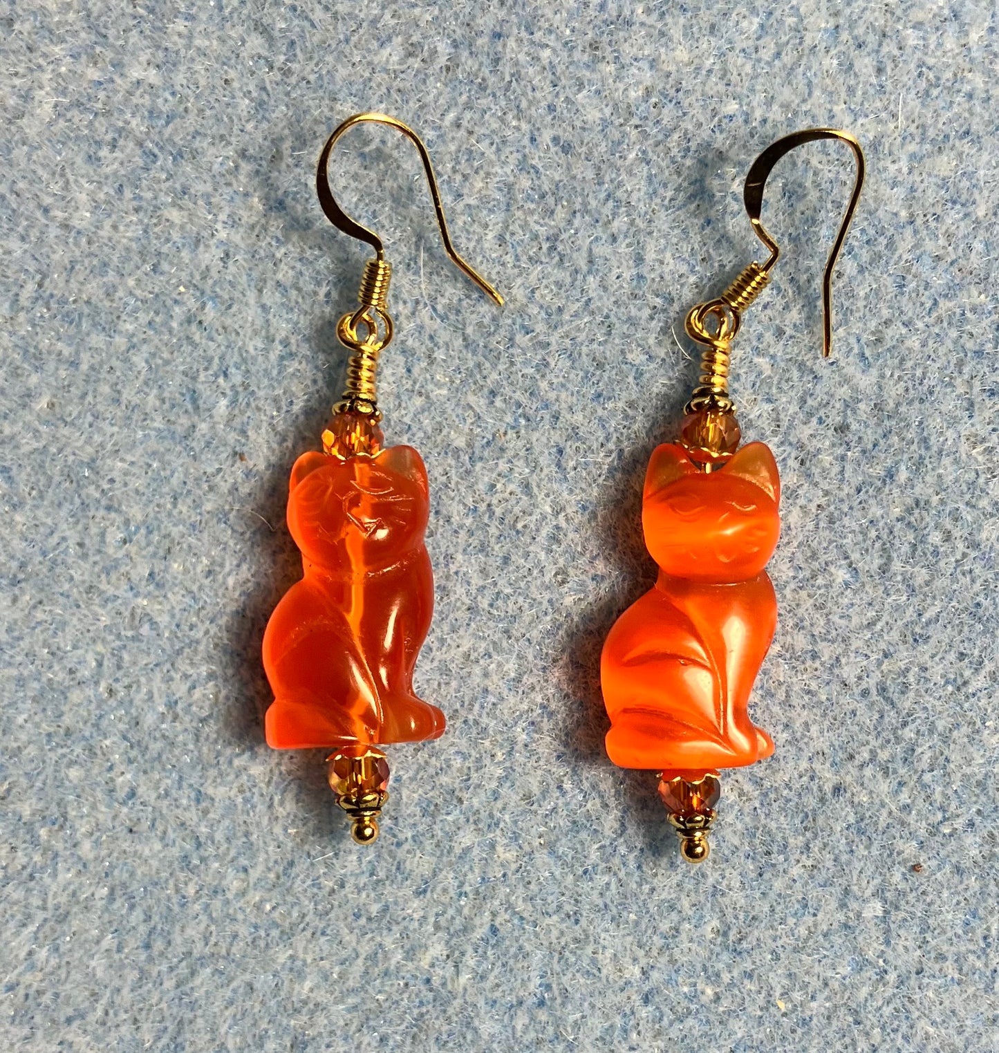 Orange fiber optic (cat’s eye) cat bead earrings adorned with orange Chinese crystal beads.