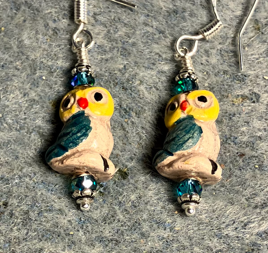 Small teal and yellow ceramic owl bead earrings adorned with teal Chinese crystal beads.