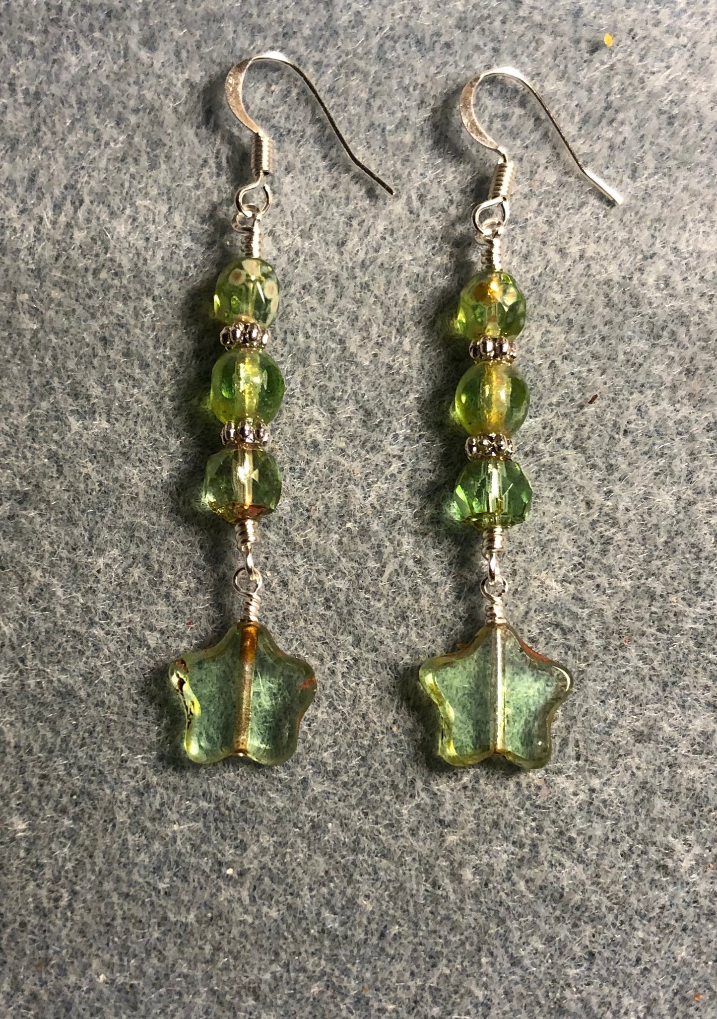 Small translucent light green Czech glass star bead earrings adorned with light green Czech glass beads.