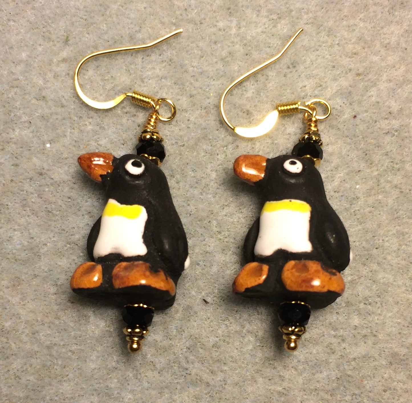 Black, brown, and white ceramic penguin bead earrings adorned with black Chinese crystal beads.