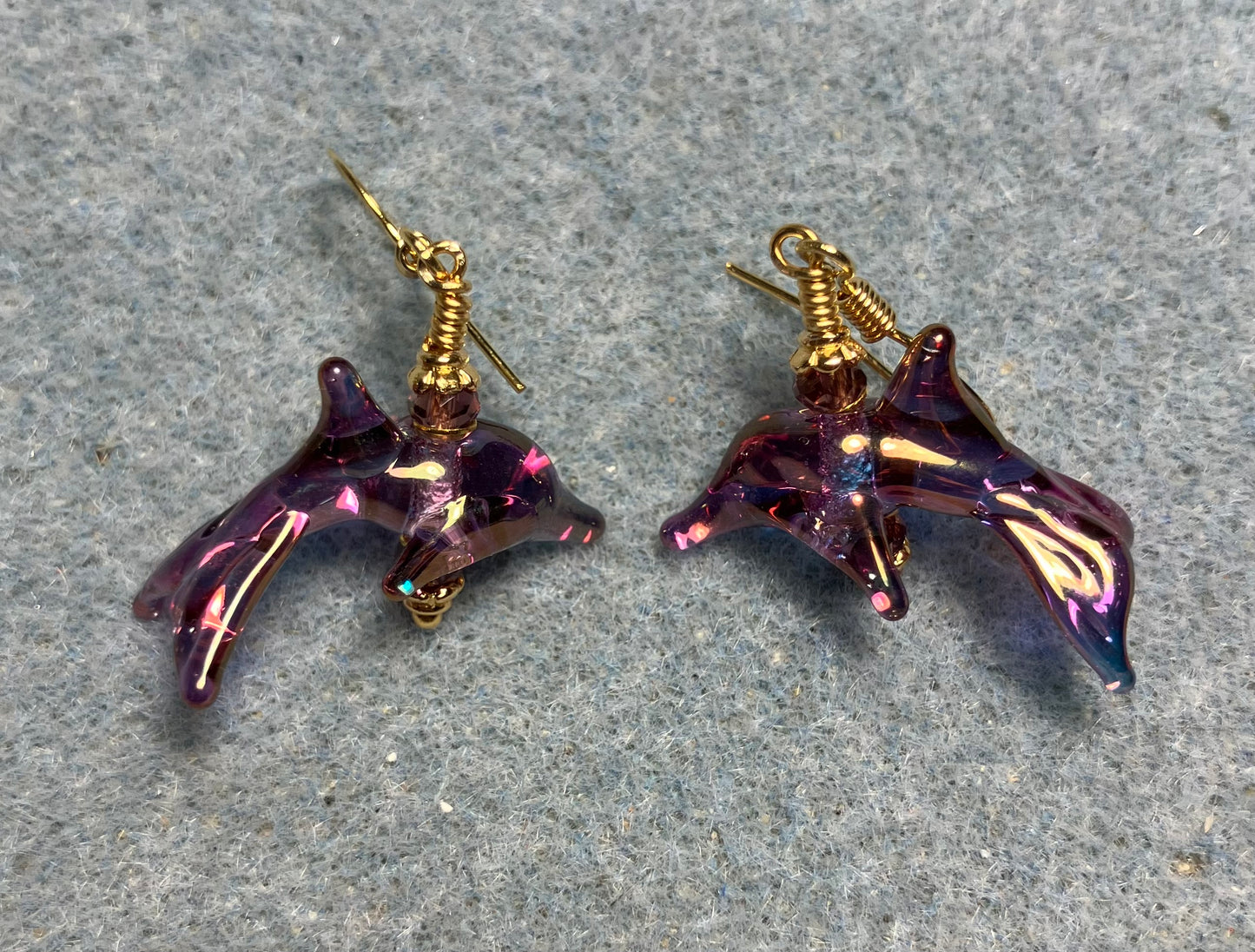 Tiny aurora borealis violet lamp work dolphin bead earrings adorned with tiny violet Chinese crystal beads.