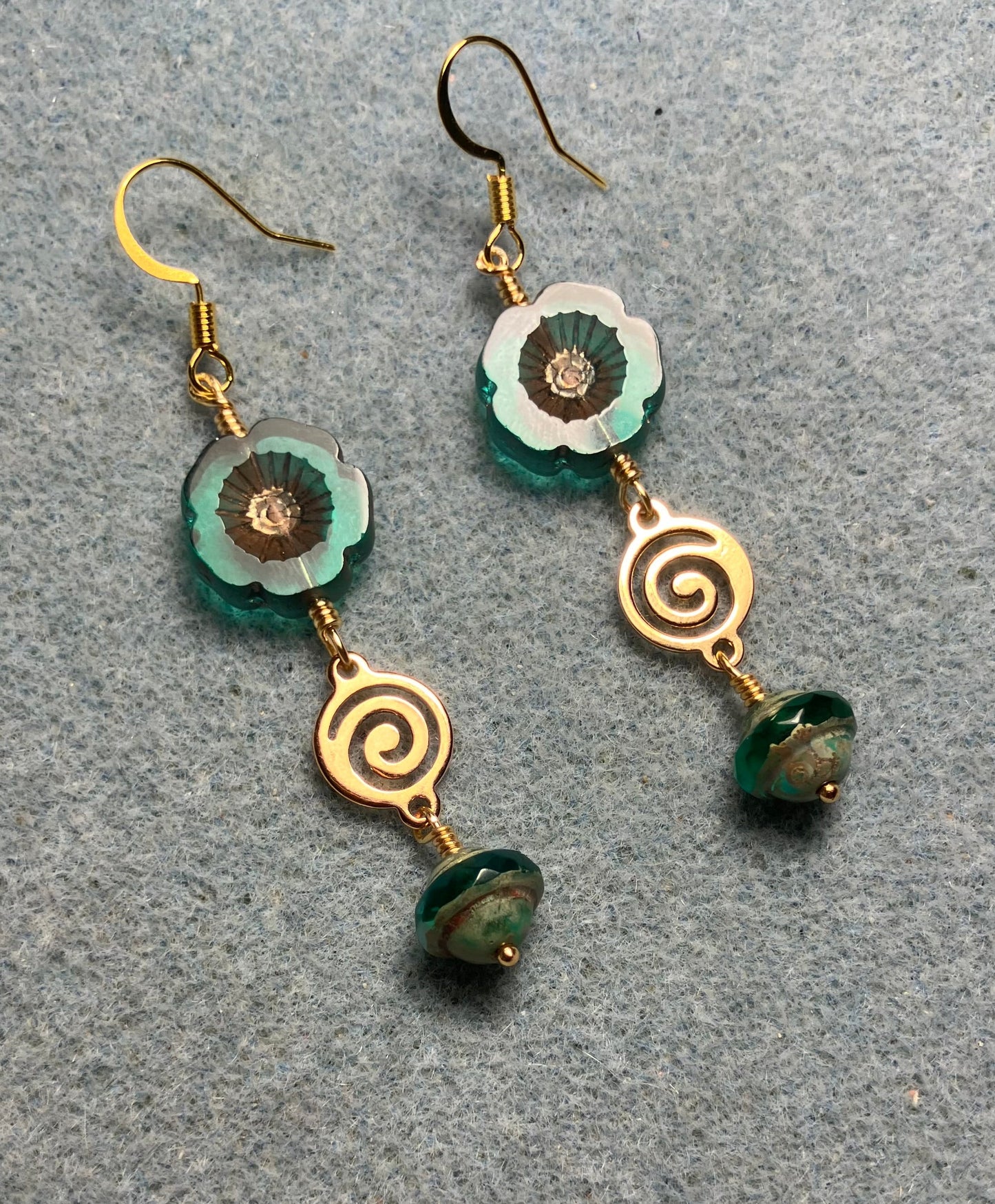 Translucent teal and gold Czech glass pansy bead earrings adorned with gold swirly connectors and teal Czech glass Saturn beads.