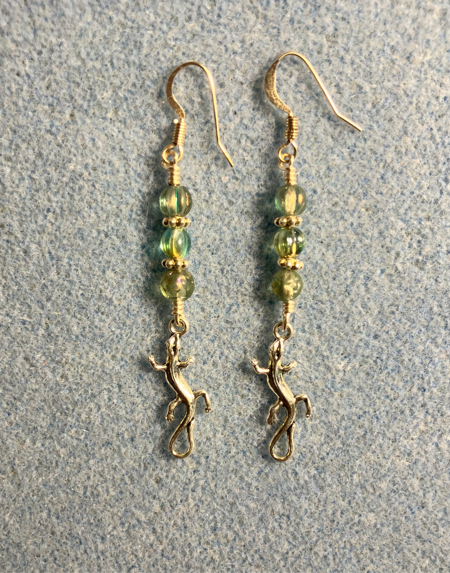 Tiny silver swirly tailed lizard charm earrings adorned with small green Czech glass beads