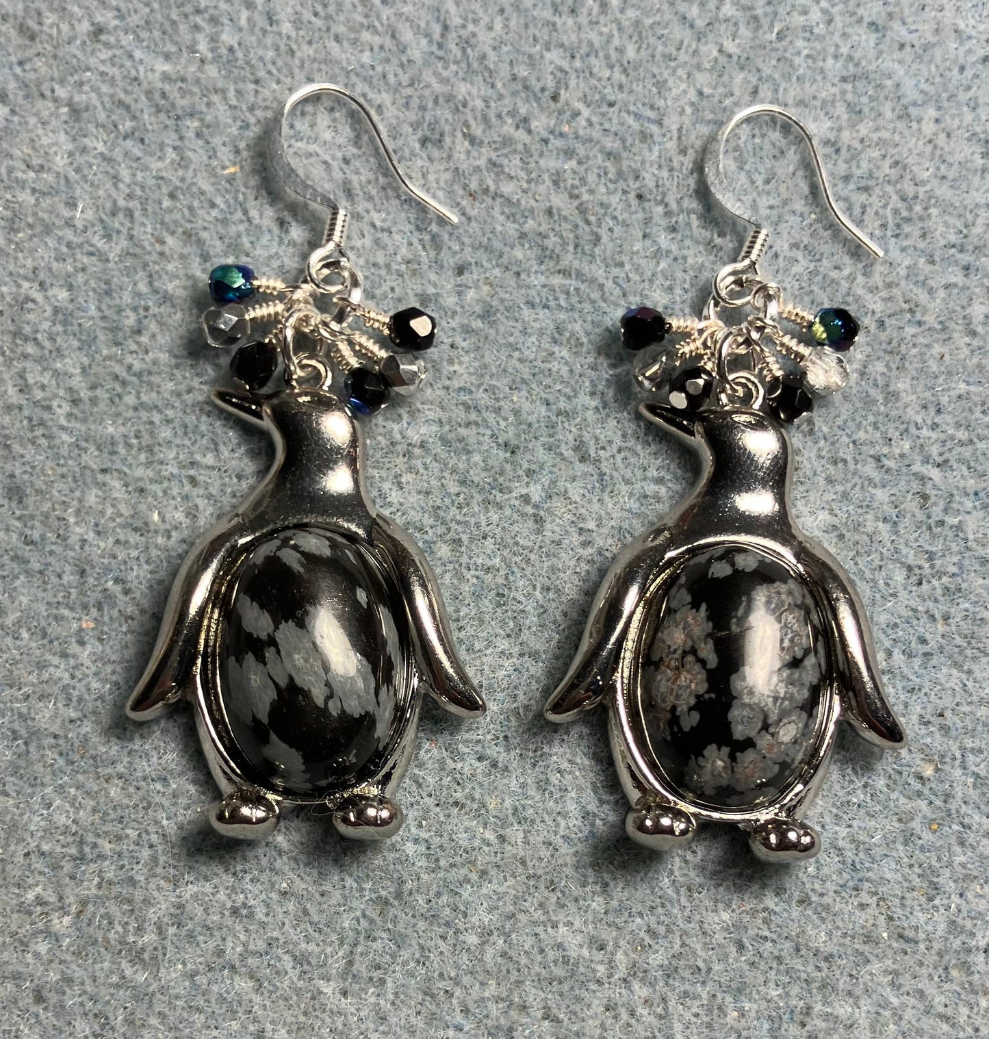 Large silver and snow jasper gemstone penguin charm earrings adorned with small dangling black and silver Czech glass beads.