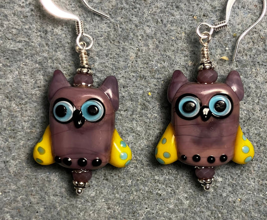 Violet, yellow, and blue lamp work owl bead earrings adorned with violet Chinese crystal beads.