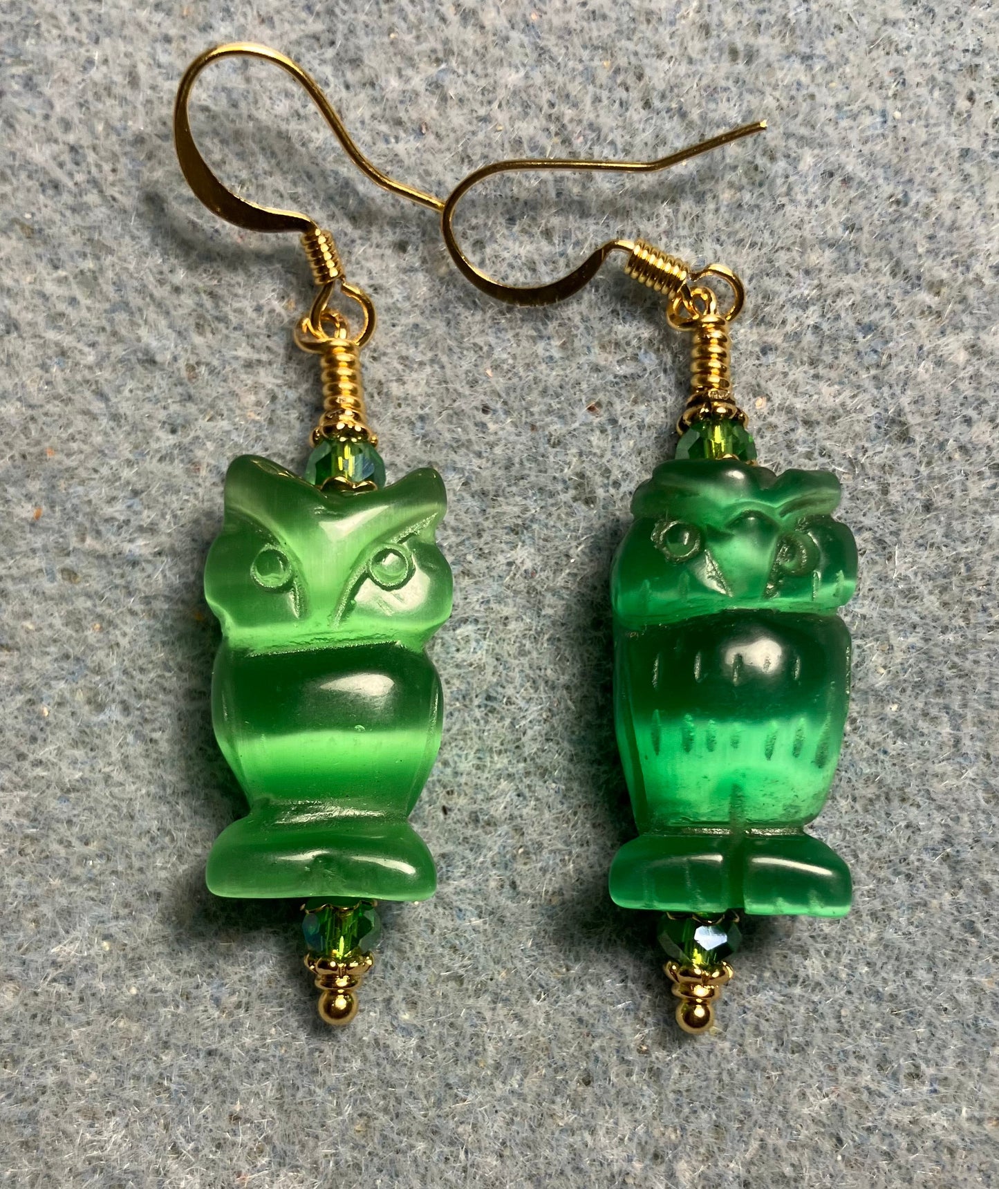 Green fiber optic (cat’s eye) owl bead earrings adorned with green Chinese crystal beads.