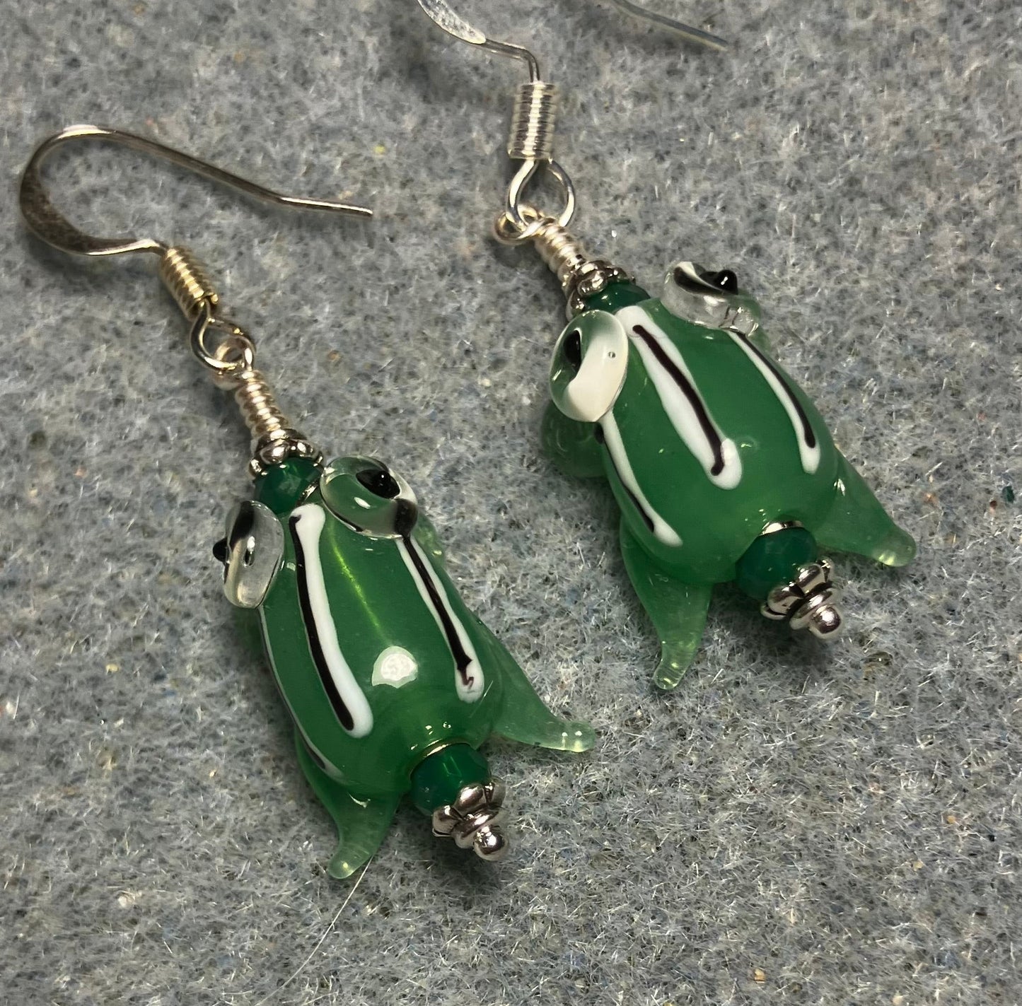 Very small green with black stripes lamp work frog bead earrings adorned with green Chinese crystal beads.
