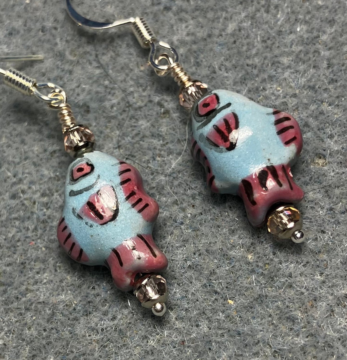 Small light blue, black, and pink ceramic fish bead earrings adorned with pink Chinese crystal beads.