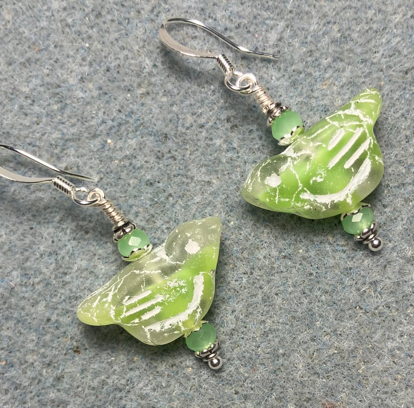 Light green (with white inlay) Czech glass bird bead earrings adorned with light green Chinese crystal beads.