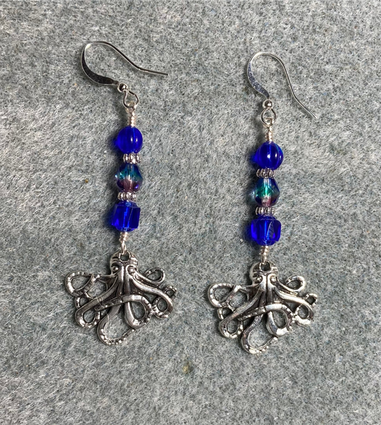 Silver octopus charm earrings adorned with dark blue Czech glass beads.