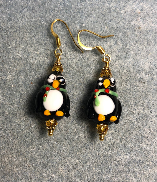 Black, white, and amber lamp work penguin bead earrings adorned with amber Chinese crystal beads.