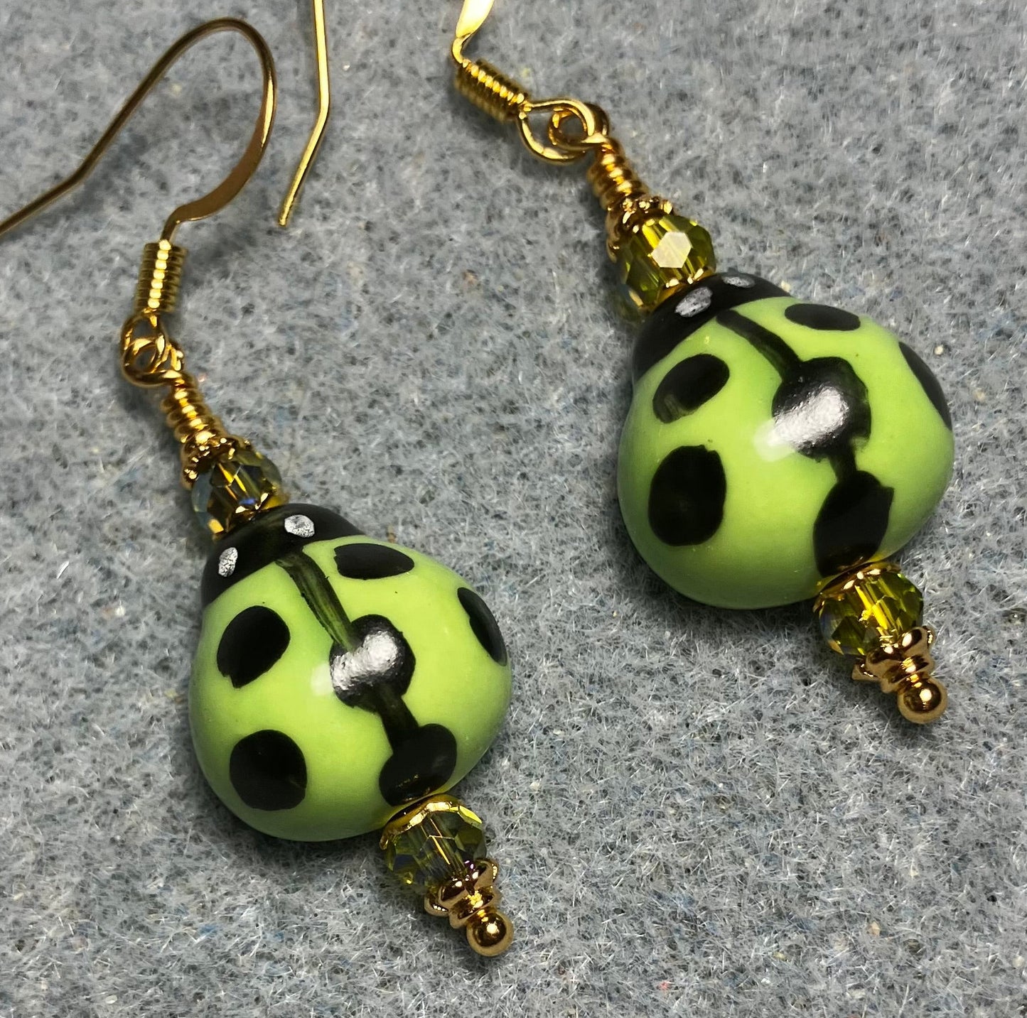 Lime green and black ceramic ladybug bead earrings adorned with lime green Chinese crystal beads.