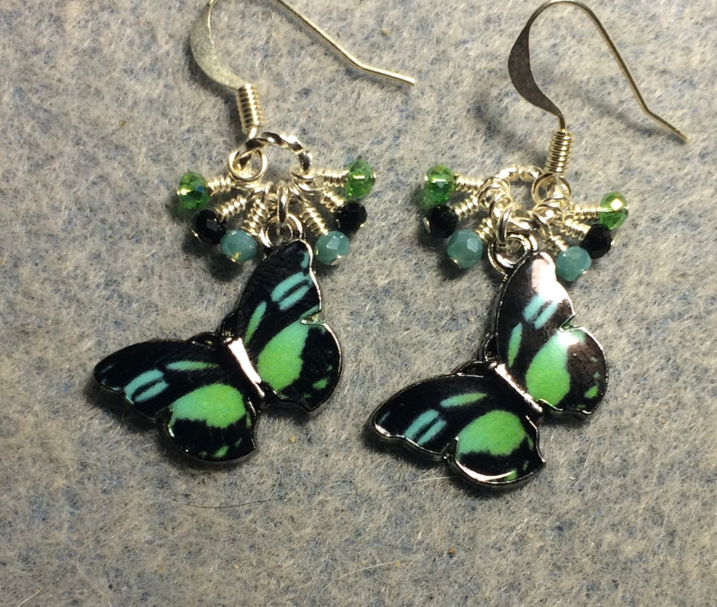 Turquoise, black, and green enamel butterfly charm earrings adorned with tiny dangling turquoise, black, and green Chinese crystal beads.