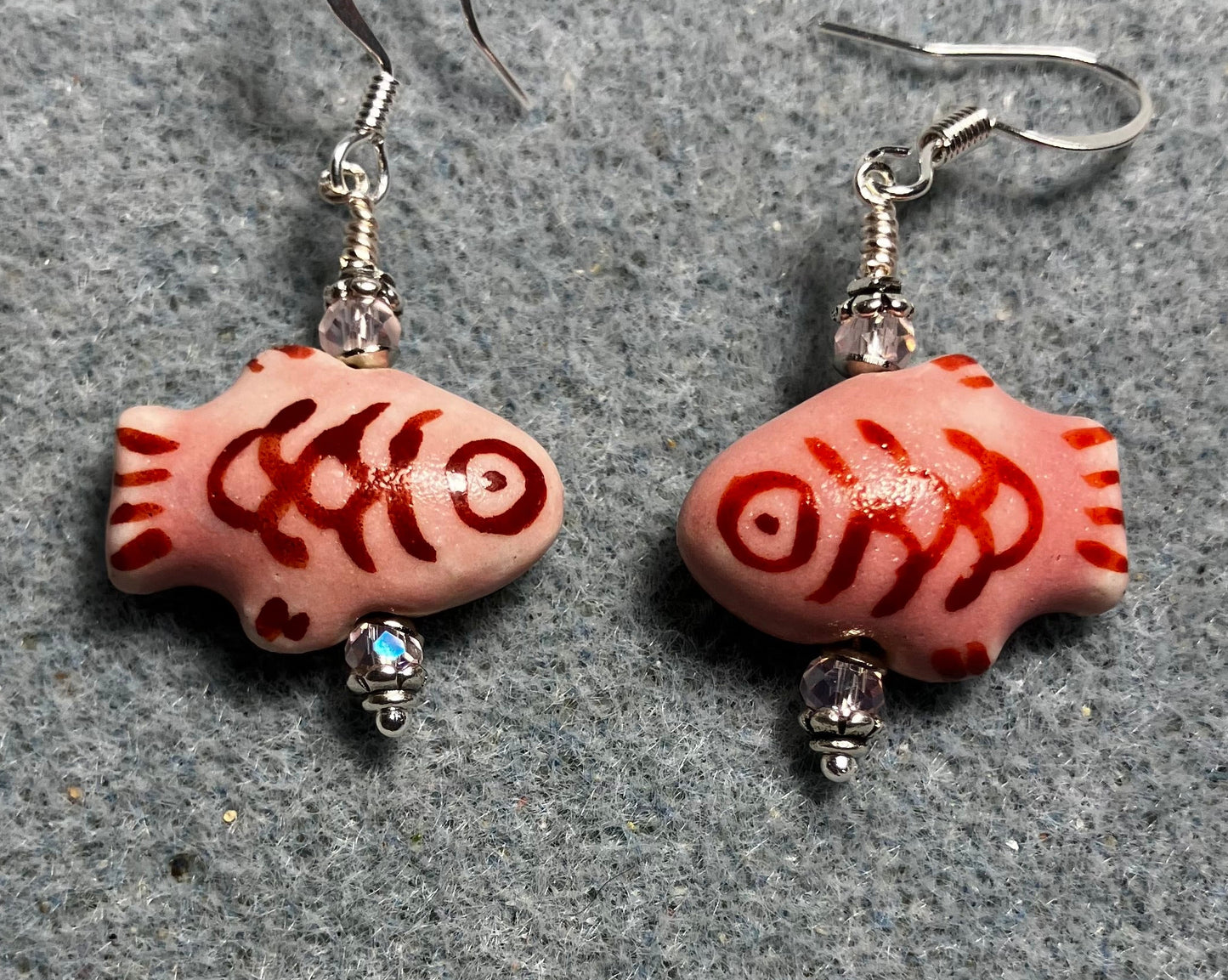 Pink and dark red ceramic fish bead earrings adorned with pink Chinese crystal beads.