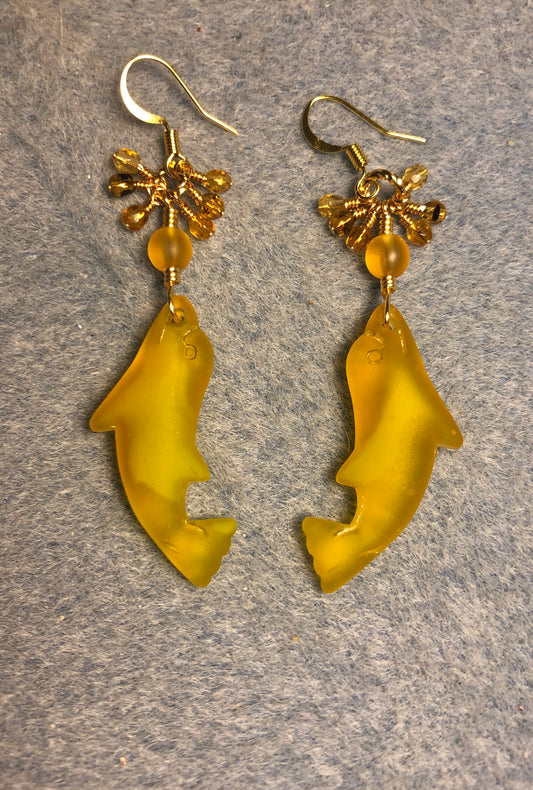 Amber sea glass dolphin pendant bead earrings adorned with amber Czech glass beads and tiny dangling amber Czech glass beads.