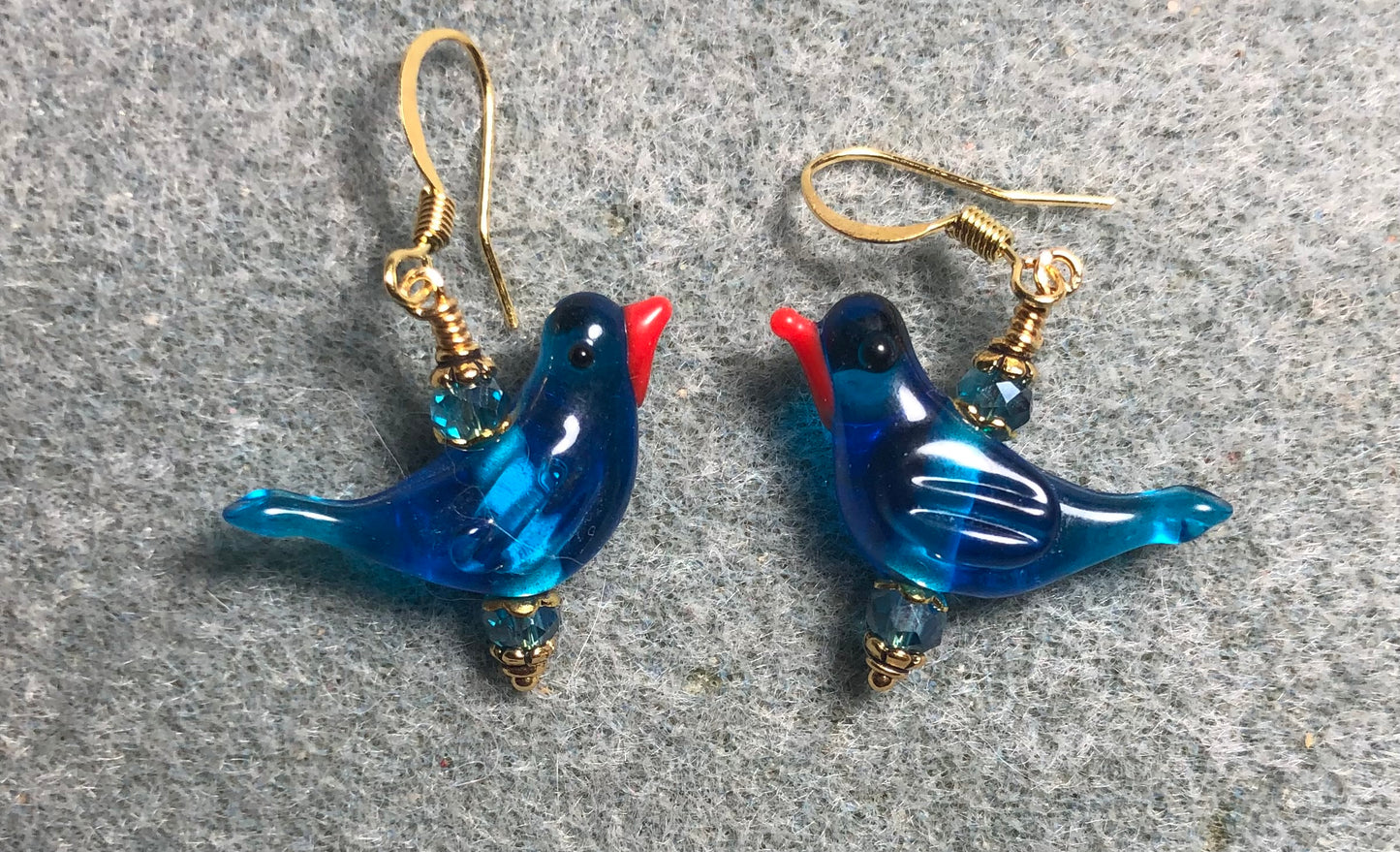 Translucent bright blue lamp work songbird bead earrings adorned with bright blue Chinese crystal beads.