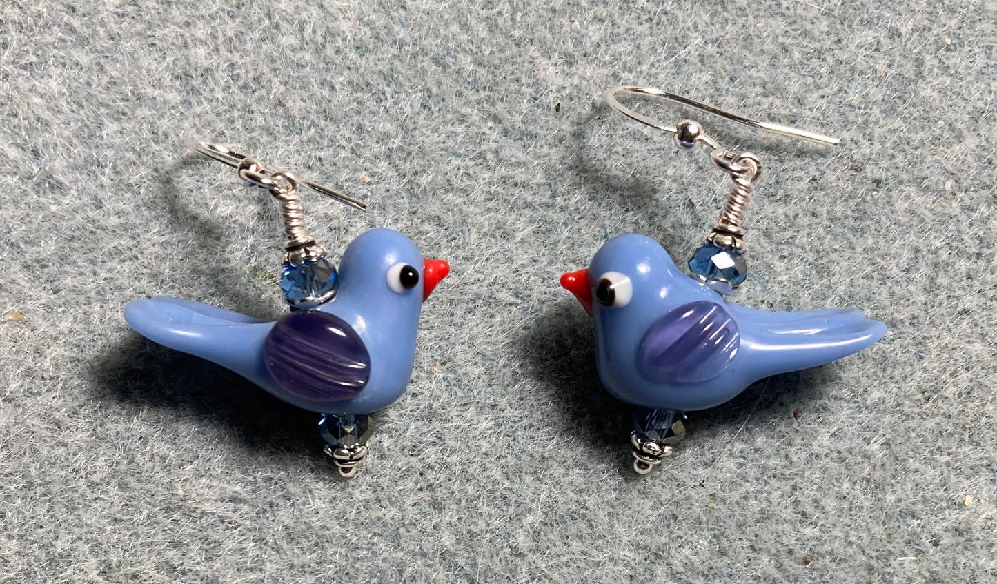 Opaque light blue lamp work songbird bead earrings adorned with light blue Chinese crystal beads.