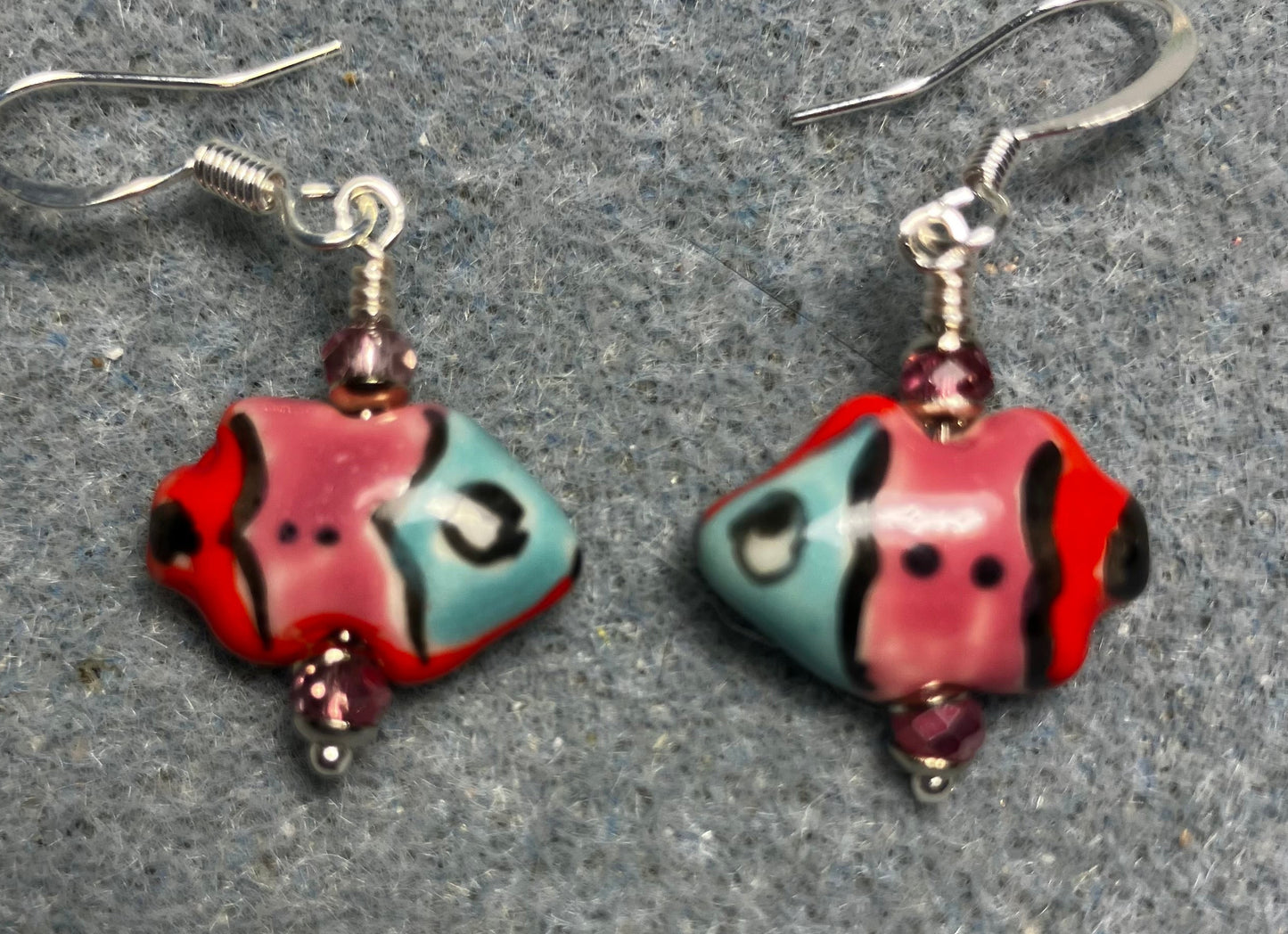 Small pink, red, and turquoise ceramic fish bead earrings adorned with sparkly pink Chinese crystal beads.