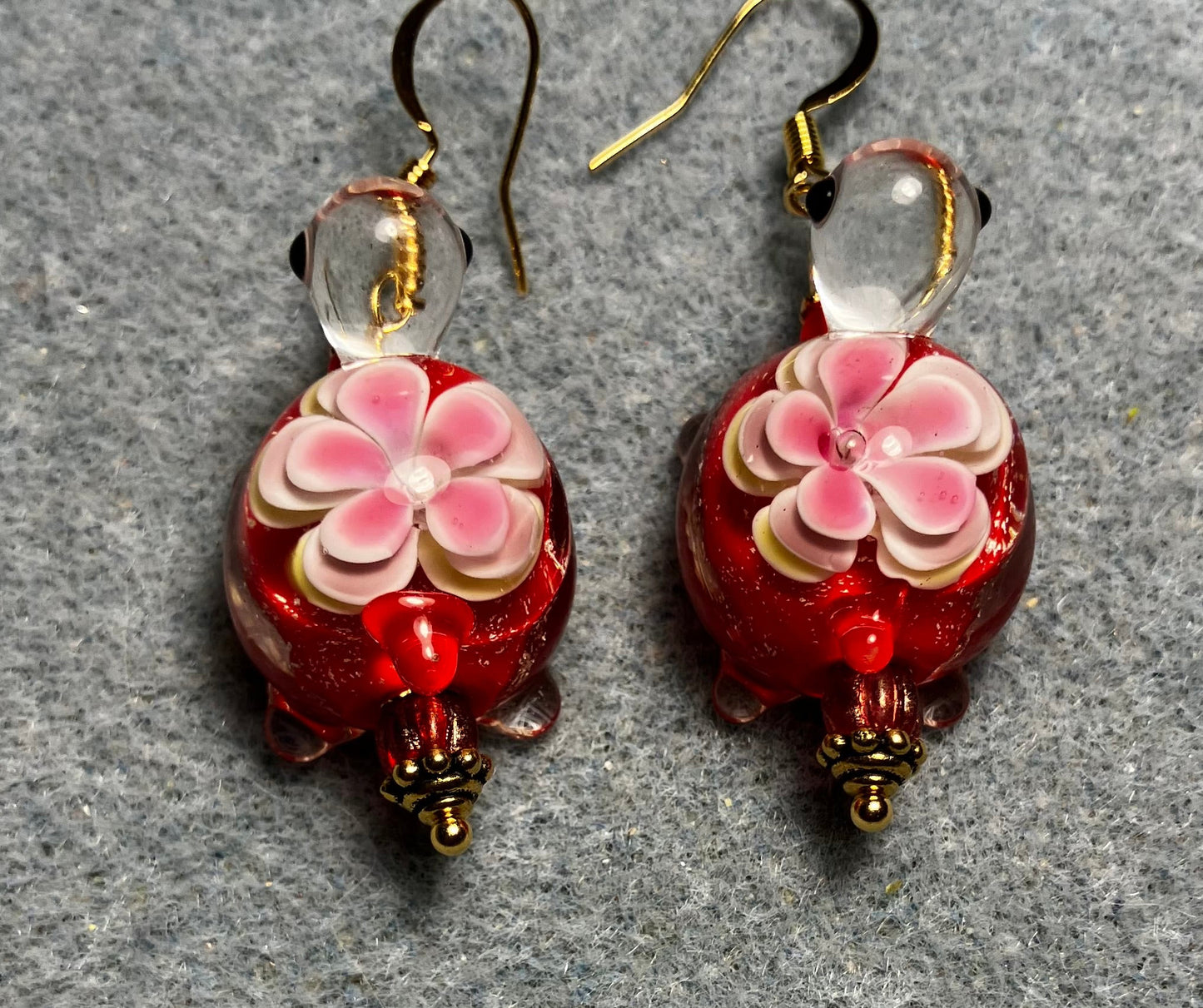 Large red and pink lamp work turtle bead earrings adorned with red Czech glass beads.