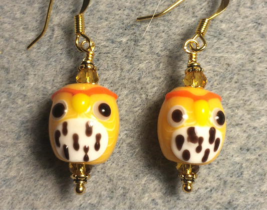 Orangish yellow and white lamp work spotted owl bead earrings adorned with orangish yellow Chinese crystal beads.