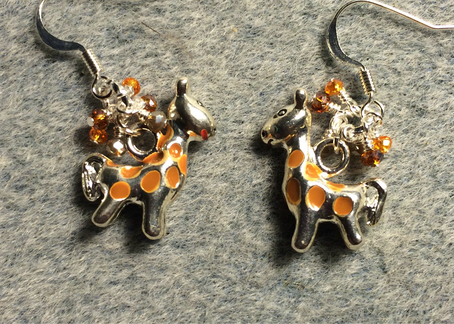 Silver and orange enamel spotted giraffe charm earrings adorned with tiny dangling orange and tan Chinese crystal beads.