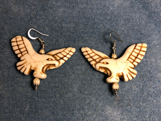 Large off white howlite gemstone flying eagle bead earrings adorned with off white Chinese crystal beads.